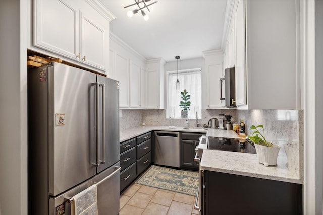 kitchen with appliances with stainless steel finishes, pendant lighting, white cabinets, decorative backsplash, and light tile patterned floors