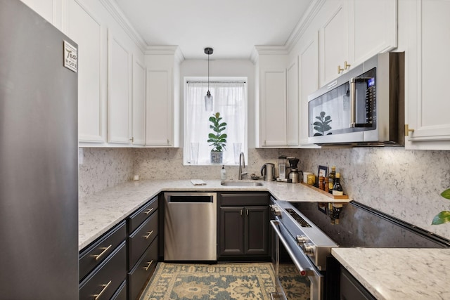 kitchen featuring stainless steel appliances, sink, pendant lighting, and white cabinets