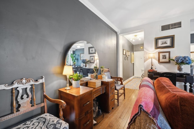 living room with ornamental molding and light wood-type flooring