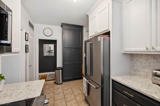 kitchen featuring light stone counters, tasteful backsplash, stainless steel appliances, and white cabinets