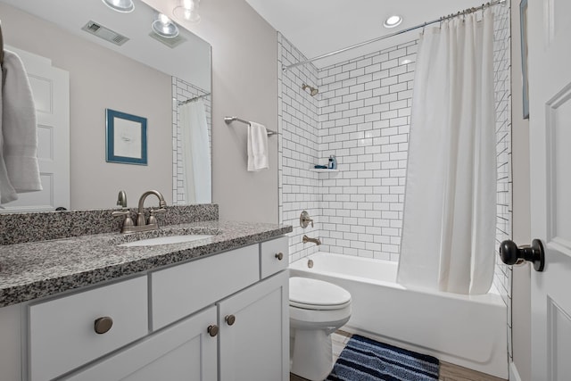 full bathroom with vanity, shower / bath combination with curtain, and toilet