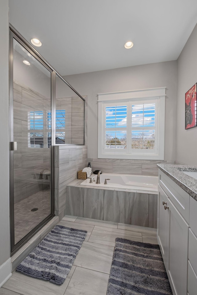 bathroom featuring shower with separate bathtub, tile patterned floors, and vanity