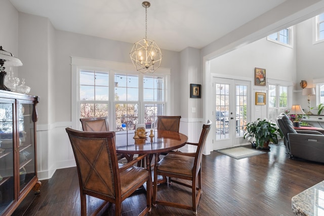 dining area featuring a wealth of natural light, a notable chandelier, and dark hardwood / wood-style flooring