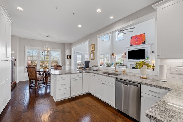 kitchen with white cabinetry, sink, stainless steel dishwasher, and kitchen peninsula