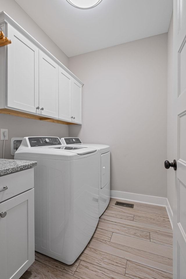 laundry room with cabinets and washer and dryer