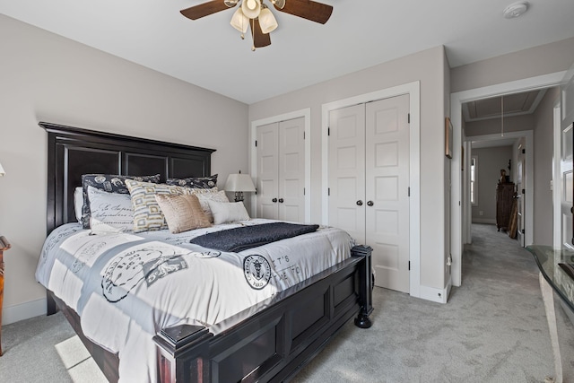 carpeted bedroom with multiple closets and ceiling fan