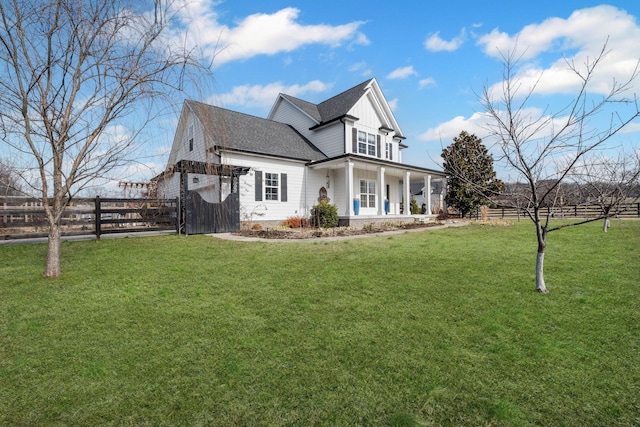 back of house featuring a lawn and covered porch