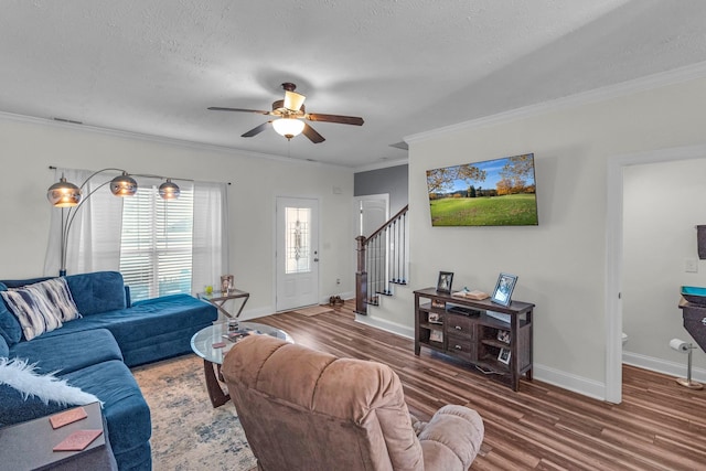 living room with hardwood / wood-style flooring, ornamental molding, ceiling fan, and a textured ceiling