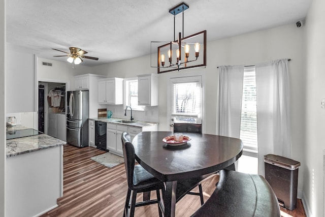 dining space with dark wood-type flooring, washing machine and clothes dryer, plenty of natural light, and sink