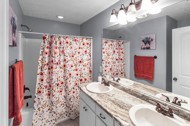 bathroom with tile patterned flooring, vanity, shower / bathtub combination with curtain, and a textured ceiling