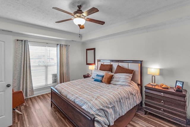 bedroom with crown molding, a textured ceiling, dark hardwood / wood-style flooring, a raised ceiling, and ceiling fan