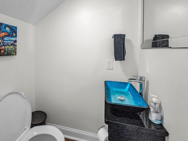 bathroom featuring toilet and a textured ceiling