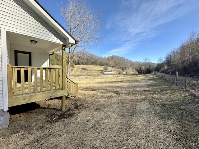 view of yard featuring a wooden deck and a rural view