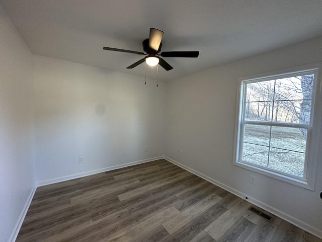 unfurnished room featuring dark wood-type flooring, ceiling fan, and a healthy amount of sunlight