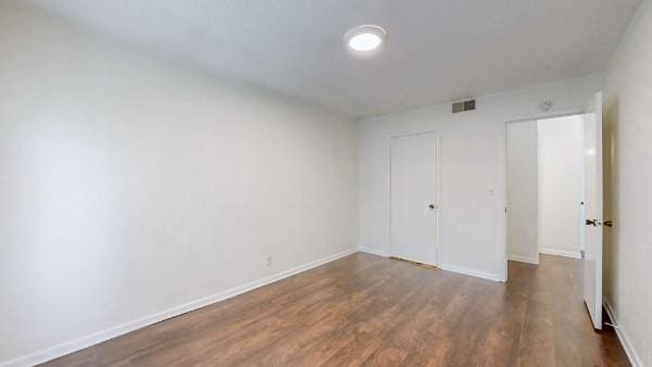 unfurnished bedroom with dark wood finished floors and baseboards