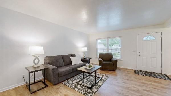 living area with light wood-type flooring and baseboards