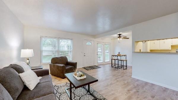 living area featuring light wood finished floors and baseboards