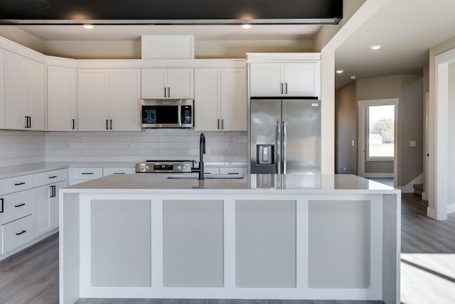 kitchen featuring appliances with stainless steel finishes, a kitchen island with sink, sink, and white cabinets