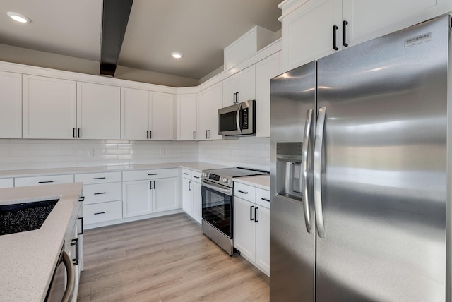 kitchen featuring light hardwood / wood-style flooring, white cabinets, stainless steel appliances, beam ceiling, and backsplash