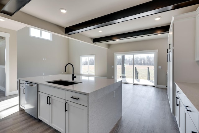 kitchen featuring sink, light hardwood / wood-style flooring, light stone counters, white cabinets, and stainless steel dishwasher