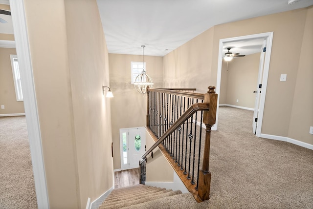 staircase featuring carpet flooring and an inviting chandelier