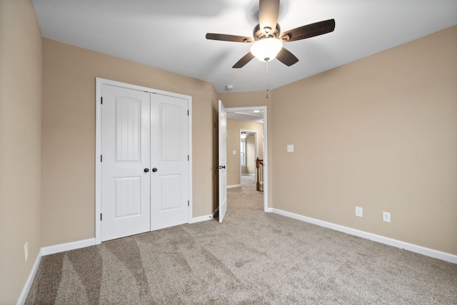 unfurnished bedroom featuring light colored carpet, a closet, and ceiling fan