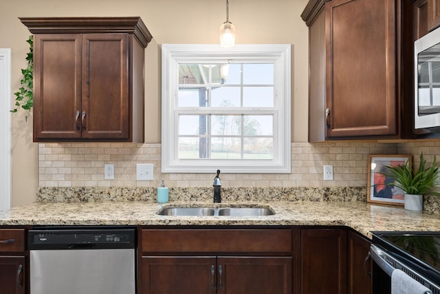 kitchen featuring tasteful backsplash, sink, light stone counters, and appliances with stainless steel finishes