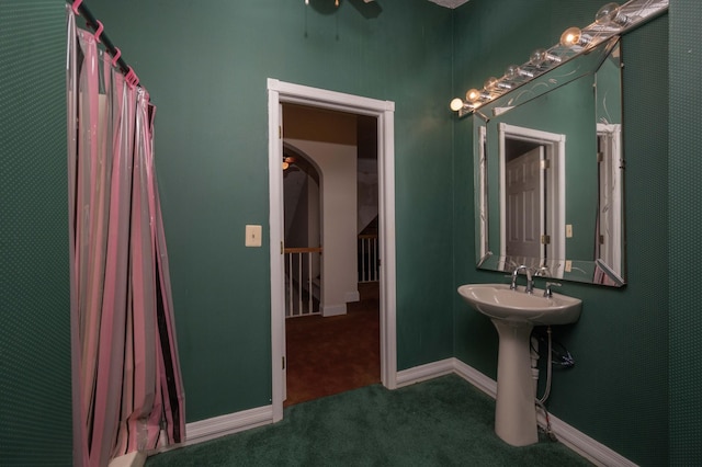 bathroom featuring a shower with curtain, ceiling fan, and sink