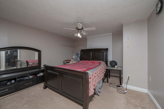 bedroom with a textured ceiling, light colored carpet, and ceiling fan