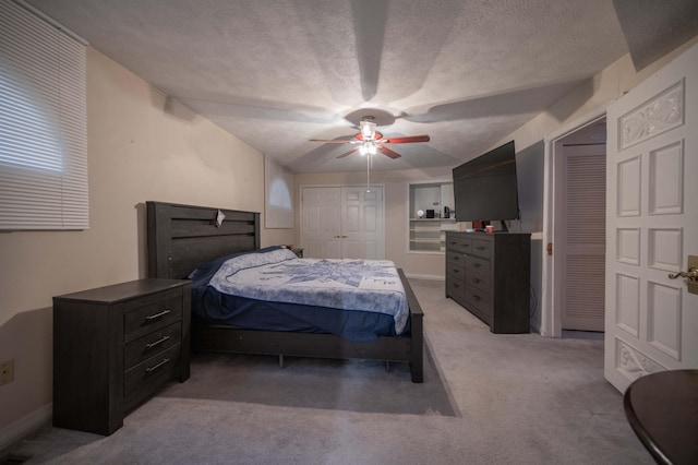 bedroom featuring light carpet, a textured ceiling, and ceiling fan