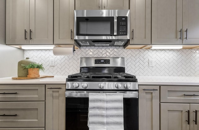 kitchen with appliances with stainless steel finishes, gray cabinets, and backsplash