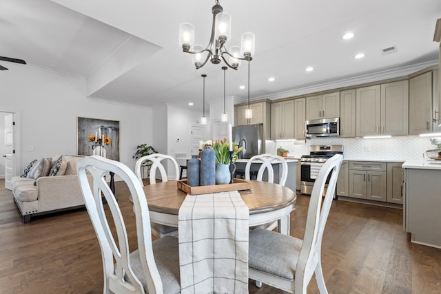 dining room with ornamental molding, ceiling fan with notable chandelier, and dark hardwood / wood-style flooring