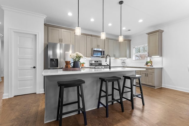 kitchen featuring stainless steel appliances, a kitchen island with sink, and hanging light fixtures