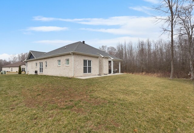 rear view of property featuring a patio area and a lawn