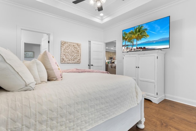 bedroom featuring a raised ceiling, ornamental molding, dark hardwood / wood-style floors, and ceiling fan