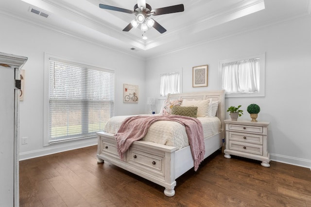 bedroom with a tray ceiling, dark wood-type flooring, ornamental molding, and ceiling fan