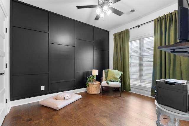 sitting room with wood-type flooring and ceiling fan