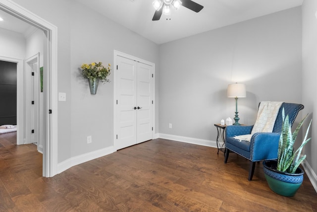 living area featuring ceiling fan and dark hardwood / wood-style flooring