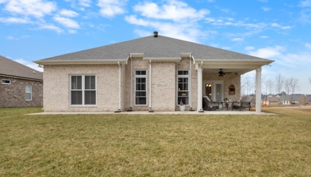 rear view of property with ceiling fan, a yard, and a patio area