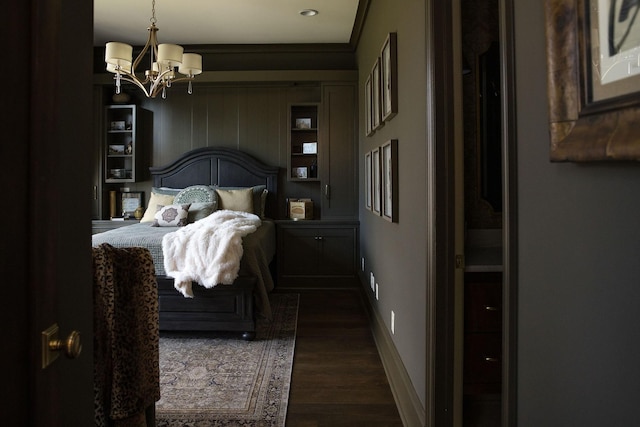 bedroom with a notable chandelier and dark wood-type flooring