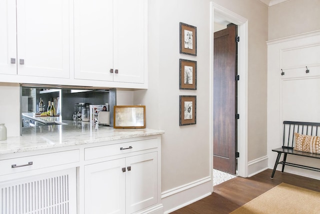 bar featuring white cabinetry, dark hardwood / wood-style floors, and light stone counters