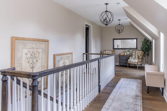 corridor featuring vaulted ceiling, dark hardwood / wood-style floors, and a notable chandelier