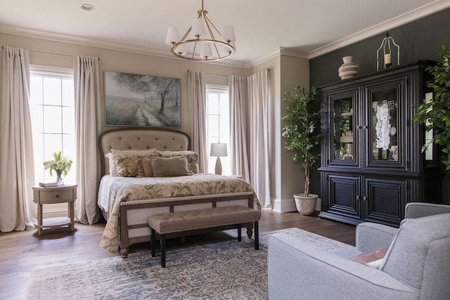 bedroom featuring dark wood-type flooring, crown molding, an inviting chandelier, and multiple windows