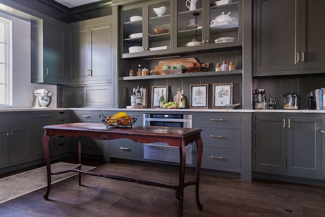 bar with dark wood-type flooring, gray cabinets, and oven