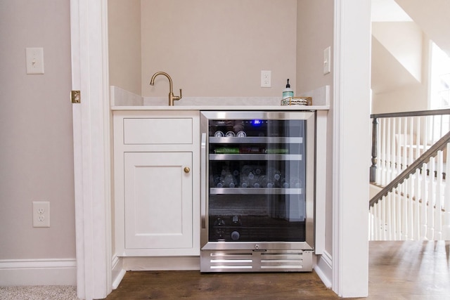 bar featuring wine cooler, white cabinetry, and dark hardwood / wood-style flooring