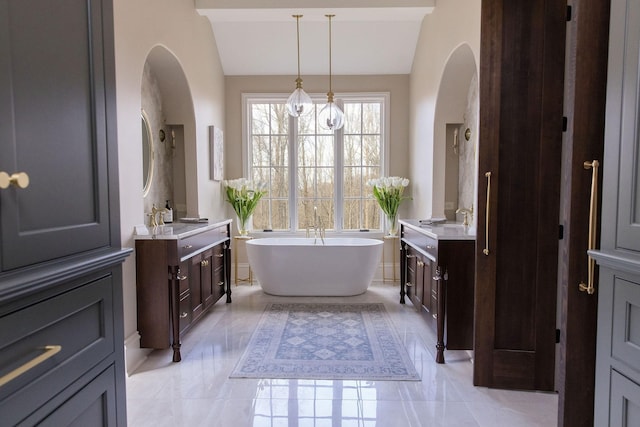 bathroom with lofted ceiling, vanity, and a washtub