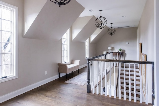 bonus room featuring dark wood-type flooring, lofted ceiling, and a notable chandelier