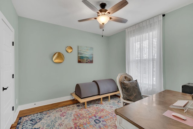 office area featuring ceiling fan, baseboards, and wood finished floors