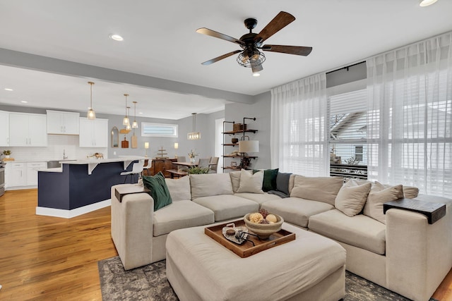 living area featuring light wood-style floors, recessed lighting, and a ceiling fan