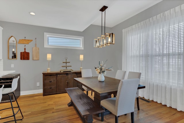 dining space with light wood-style floors, recessed lighting, a notable chandelier, and baseboards